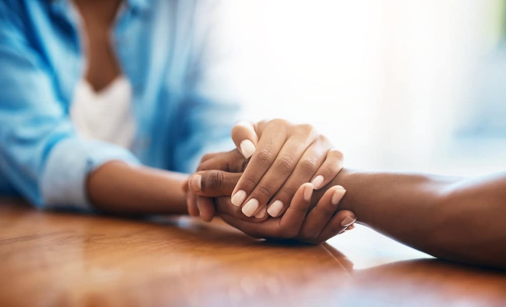 Image shows hands clasped together